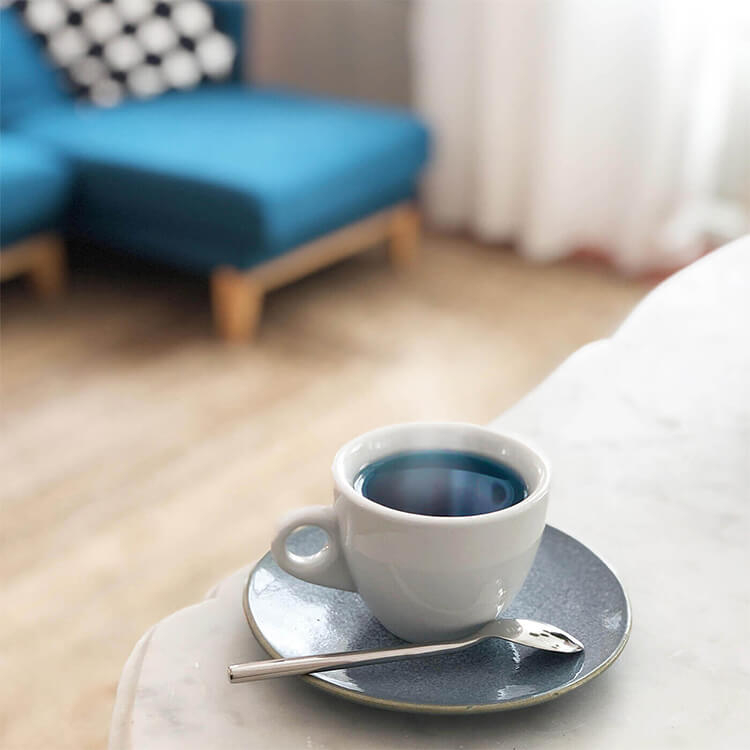 Une tasse de thé bleu chaud.
